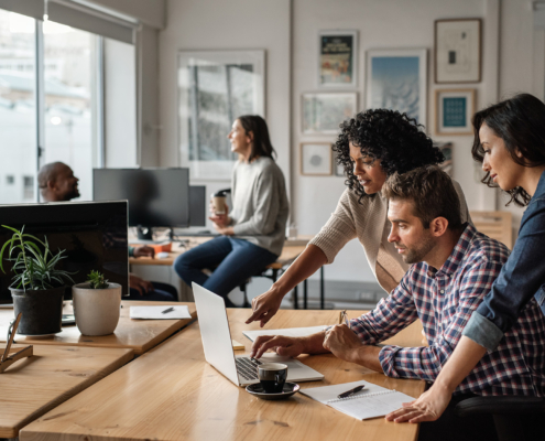 Group Of Workers Looking At Laptop