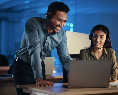 Two Tech Professionals Looking At Laptop In Office